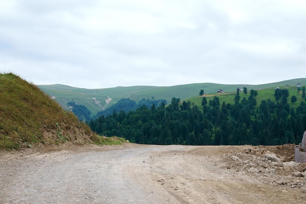 Paisaje montañoso georgiano con una carretera rural con vistas a los bosques