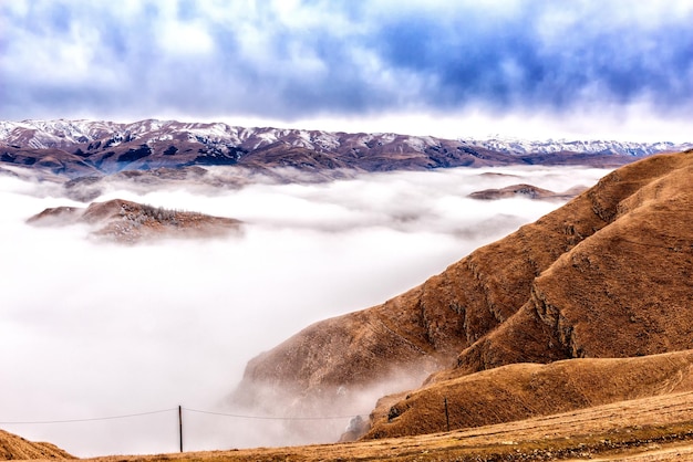 Paisaje montañoso invernal de Daguestán con nubes debajo de los picos de las montañas