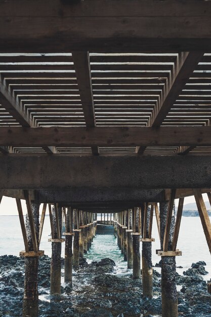 Foto paisaje de un muelle de madera sobre el mar en un lugar rocoso y hermoso - nadie en el lugar y mal tiempo - lanzarote, islas canarias