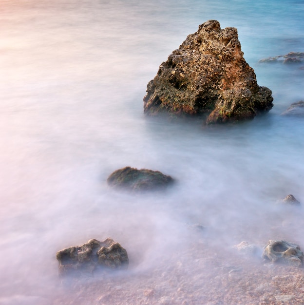 Paisaje natural de mar y roca al atardecer.