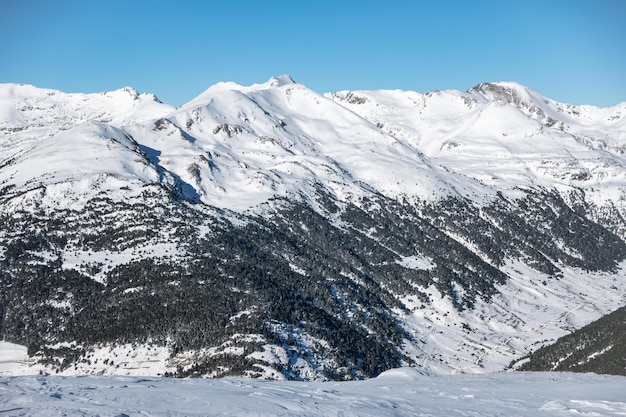 Paisaje nevado con árboles y alta montaña en la cordillera de los Pirineos Andorra