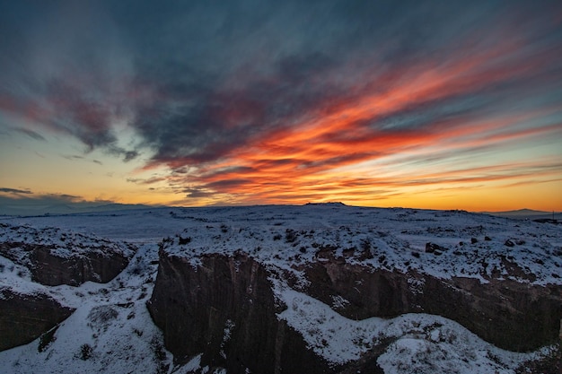 Paisaje nevado con rocas al atardecer