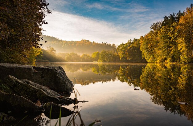 Foto paisaje de niebla del lago con follaje de otoño y reflejos de árboles en styria thal austria