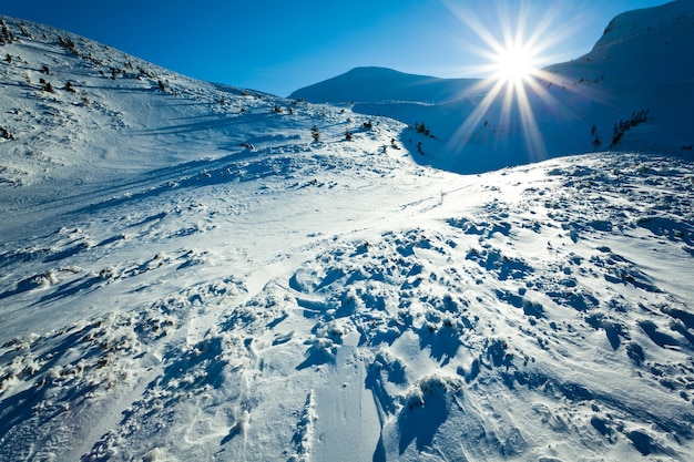 Paisaje de nieve invierno valle y montañas y sol arriba en claro día helado de invierno. Vista del concepto de naturaleza del país de las maravillas de invierno