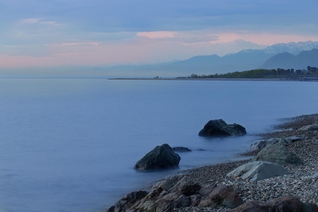 Paisaje de noche azul con mar y montaña.