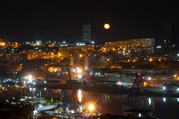 Paisaje nocturno con una luna amarilla sobre la bahía