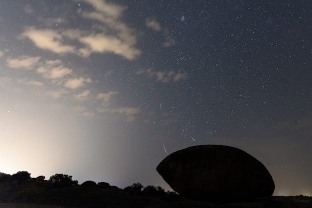 Paisaje nocturno con meteoro Perseidas en Barruecos. España.