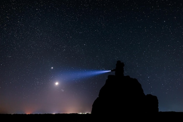 Paisaje nocturno con silueta humana.