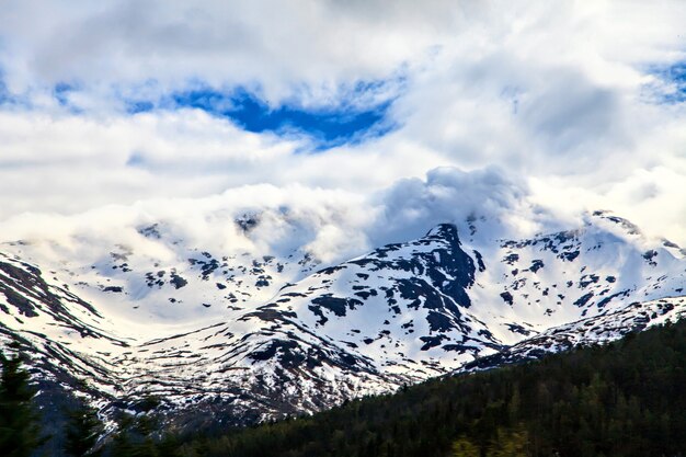 El paisaje noruego: montaña nevada en las nubes