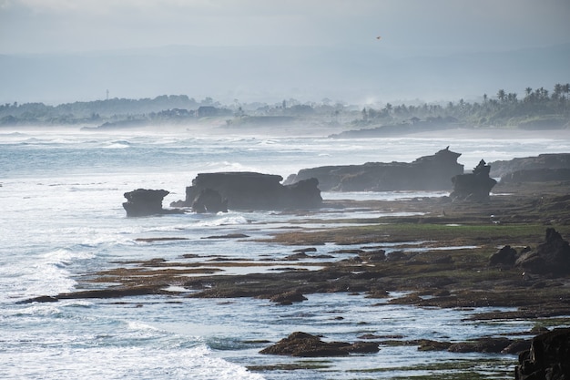 Paisaje de olas golpeando rocas en la costa en Bali, Indonesia