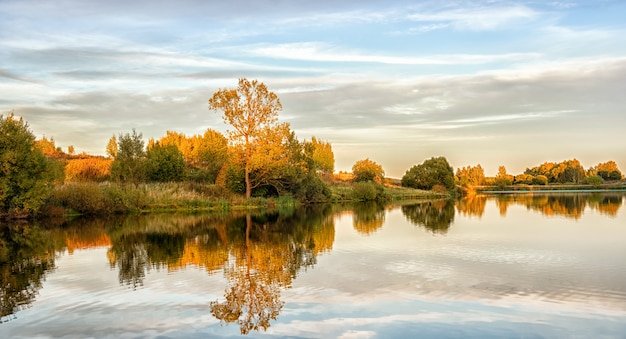 Paisaje otoñal con agua, árboles coloridos.