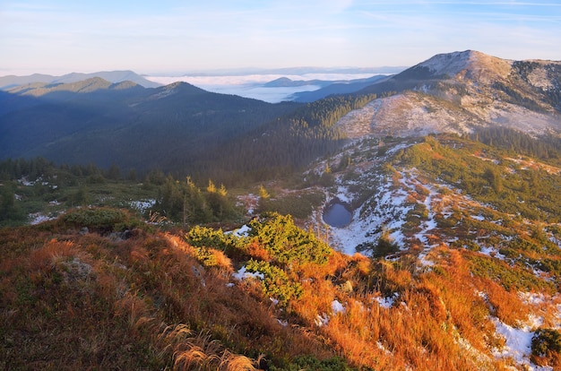 Paisaje otoñal. Lago de montaña. Primera nieve en la temporada baja. Cárpatos, Ucrania, Europa