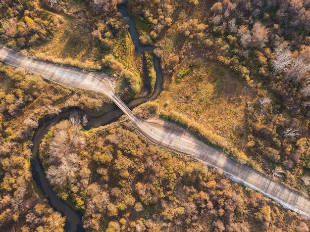 Paisaje otoñal con río y puente.