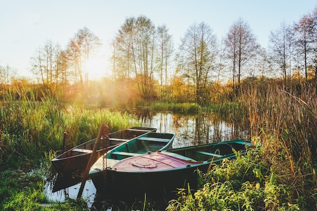 Paisaje de otoño en el río al atardecer con barcos