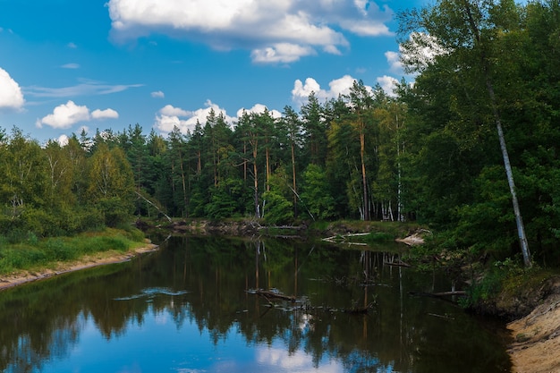 Paisaje de otoño El río fluye a través del bosque cielo azul con nubes