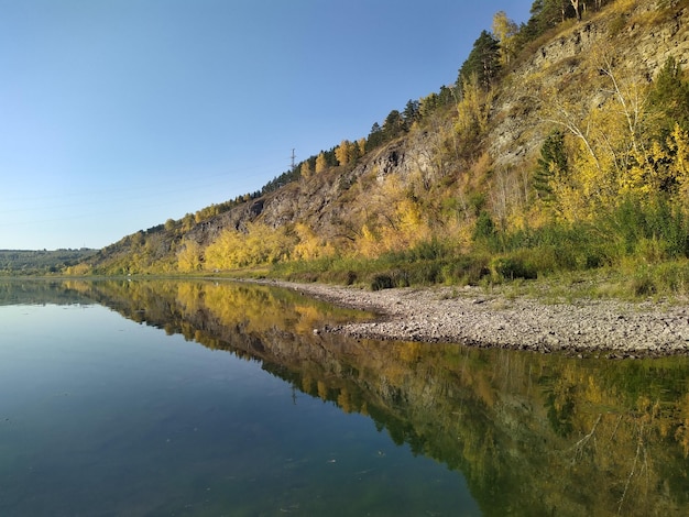 Foto paisaje de otoño con río y montaña y árboles con hojas amarillas