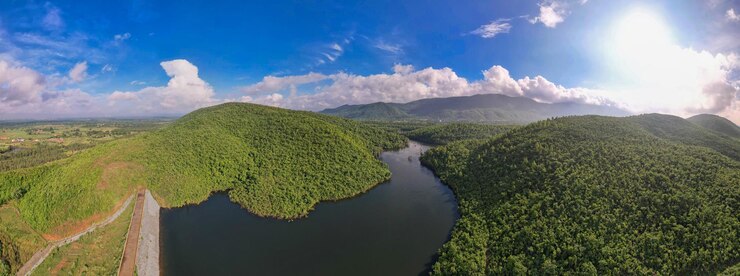Paisaje panorámico aéreo con verdes colinas, ríos y bosques.