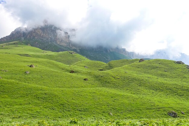 El paisaje del paso verde de Aktoprak en el Cáucaso, la carretera y las montañas bajo nubes grises KabardinoBalkaria Rusia