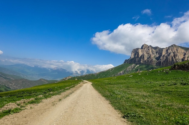 El paisaje del paso verde de Aktoprak en el Cáucaso, la carretera y las montañas bajo nubes grises KabardinoBalkaria Rusia