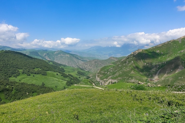 El paisaje del paso verde de Aktoprak en el Cáucaso, la carretera y las montañas bajo nubes grises KabardinoBalkaria Rusia