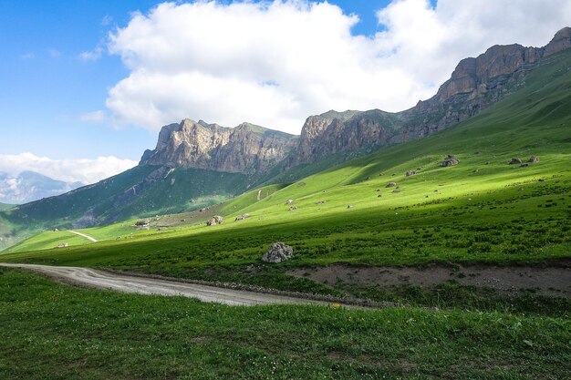El paisaje del paso verde de Aktoprak en el Cáucaso, la carretera y las montañas bajo nubes grises KabardinoBalkaria Rusia