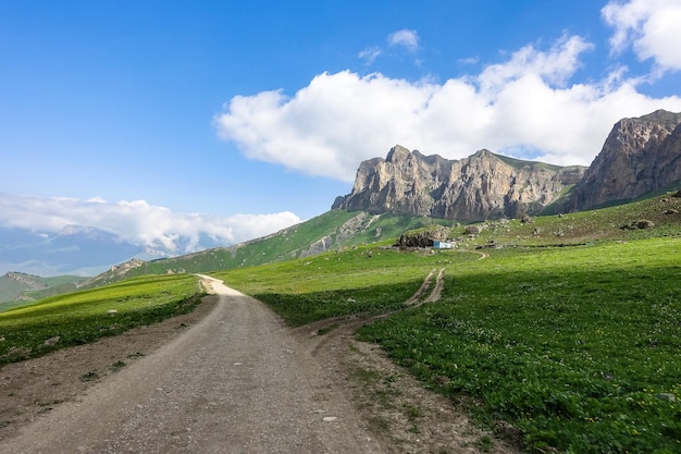 El paisaje del paso verde de Aktoprak en el Cáucaso, la carretera y las montañas bajo nubes grises KabardinoBalkaria Rusia