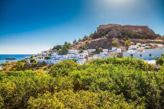 Paisaje con pequeñas casas blancas y la antigua Acrópolis de Lindos, la isla de Rodas, Grecia