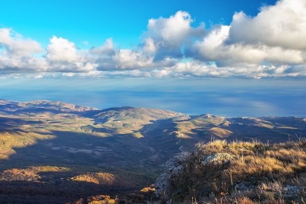 Paisaje desde el pico de la montaña con mar y majestuosas nubes en el cielo