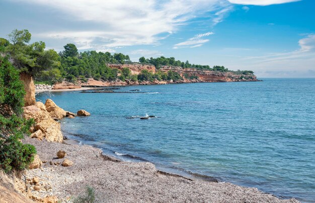 Paisaje de playa, bahía, cala en un día soleado con nubes