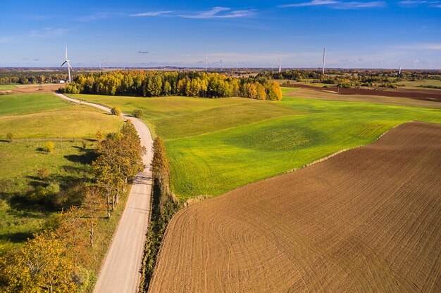 Foto un paisaje de primavera con un campo joven arado hierba verde y molinos de viento brotes frescos