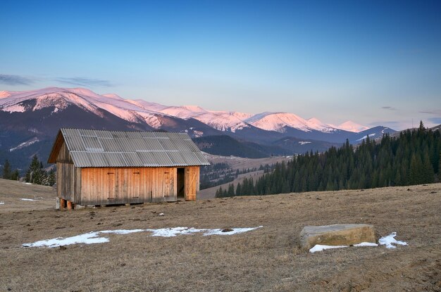 Paisaje primaveral con casita de madera para heno. Montañas de los Cárpatos, Ucrania, Europa