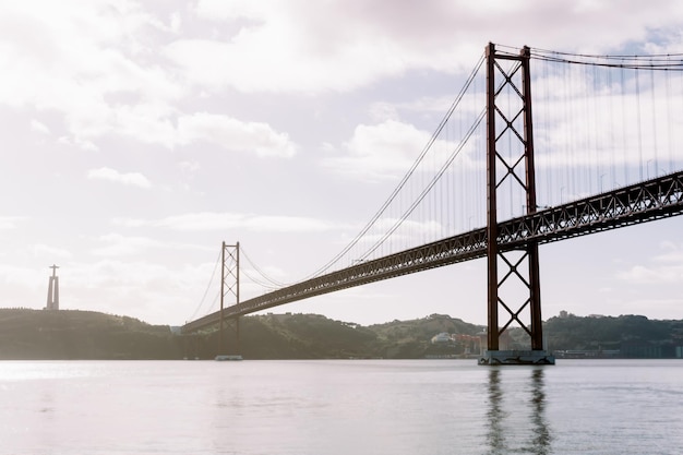 Foto paisaje del puente 25 de abril y la estatua de cristo rey en lisboa portugal