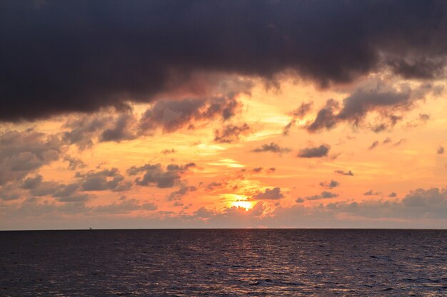 Paisaje y puesta de sol luces de mar reflejo rojo anaranjado.