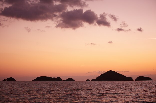 Paisaje. Puesta de sol sobre las montañas y el mar.