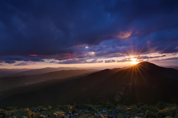 Paisaje de puesta de sol de verano de las montañas de los Cárpatos con cielo azul y bosque verde