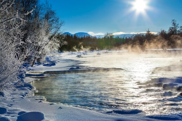 Paisaje de río de invierno con niebla en un día soleado