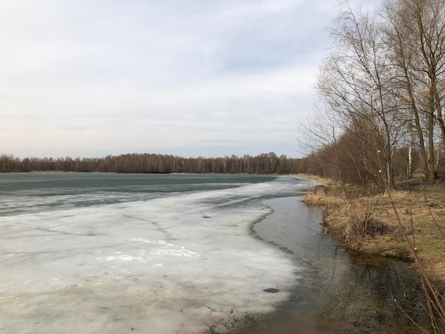 Foto paisaje de río o lago de principios de primavera con hielo derretido en la superficie del agua