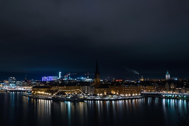 Paisaje de un río rodeado de edificios y luces en la noche en Estocolmo, Suecia