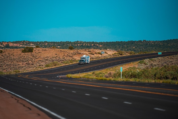 Paisaje con rocas, cielo soleado con nubes y hermosa carretera asfaltada por la noche en verano