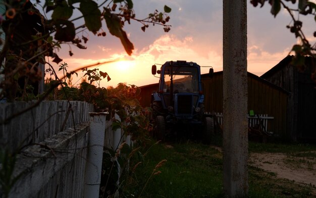 Paisaje rural con campo al atardecer y pueblo en la región de vologda de fondo