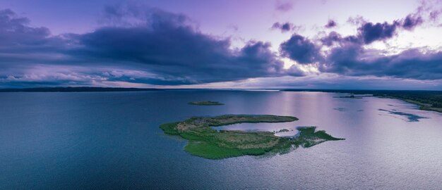 Paisaje rural de puesta de sol de verano con una pequeña isla de río y un cielo colorido espectacular vista panorámica aérea de fondo natural