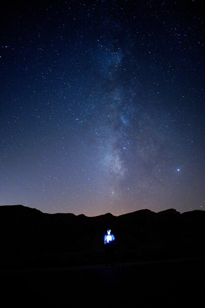 Foto paisaje de silueta contra el campo de estrellas por la noche