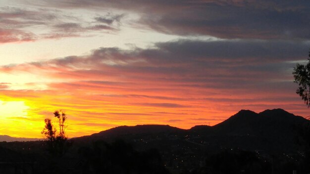 Paisaje de silueta contra el cielo naranja del atardecer