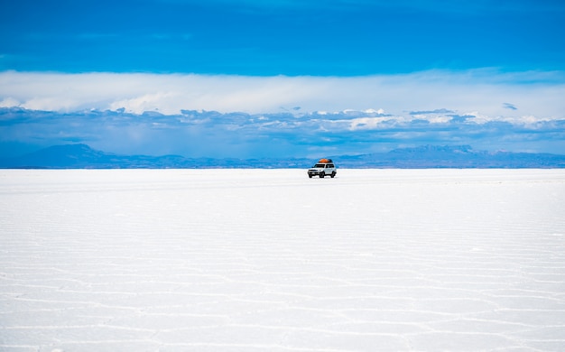 Paisaje de sol del Salar de Uyuni en Bolivia y coche