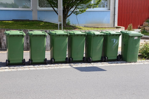 Foto el paisaje soleado de los contenedores de basura verdes en la calle