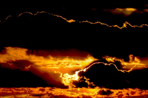 paisaje sonoro con sol y luz naranja, cielo dramático con luz dorada y nubes densas
