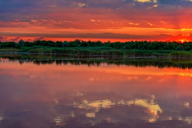 Paisaje de la tarde con el sol poniente y el reflejo del cielo en el agua