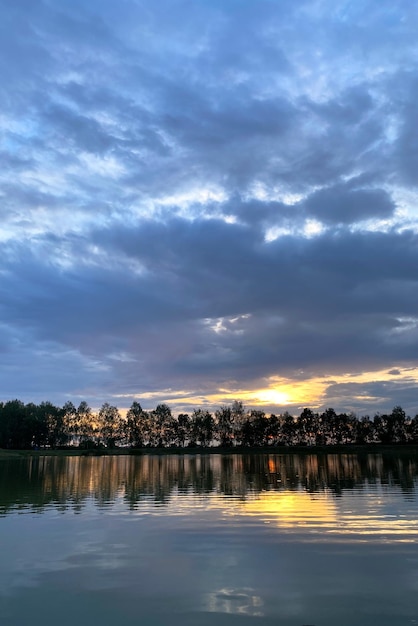 Paisaje de la tarde de verano en la puesta del sol del río cerca del agua