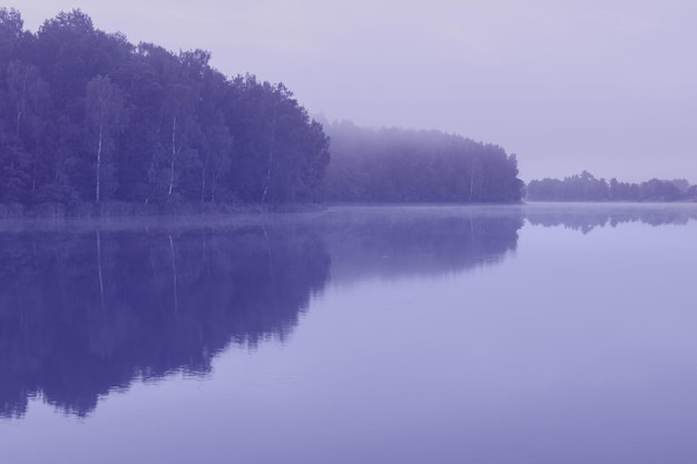 Paisaje tonificado con hermoso lago de verano en la mañana, color del año 2022