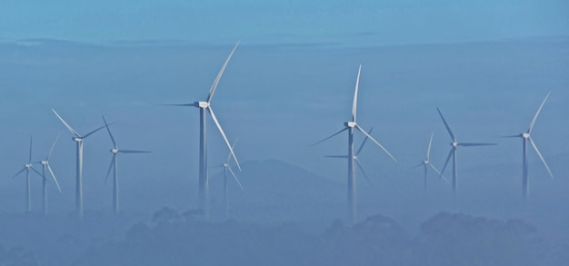 paisaje con turbinas de viento en la niebla de la mañana